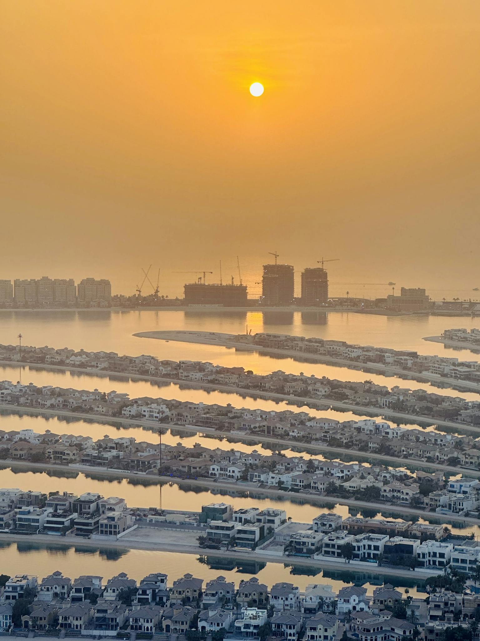 Stunning aerial view of Palm Jumeirah at sunset in Dubai, UAE, showcasing the vibrant cityscape.